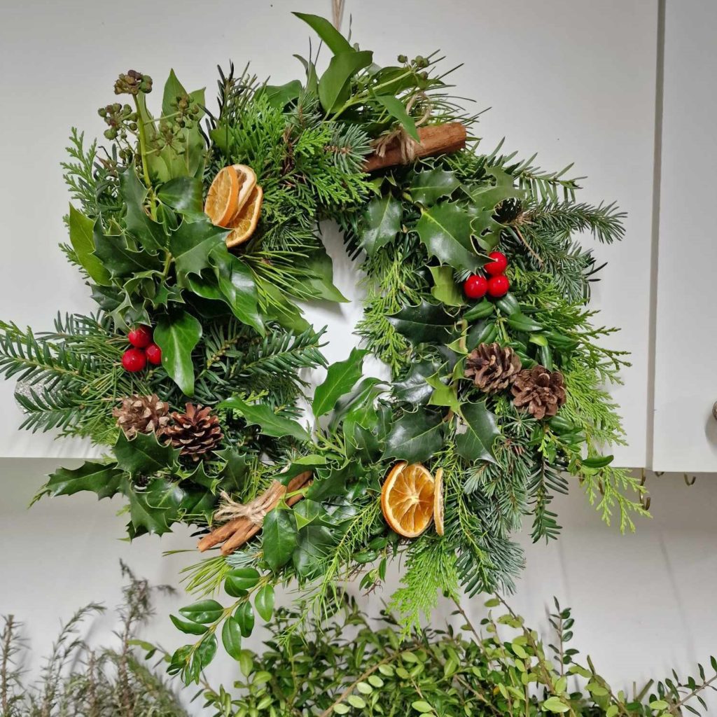 Fresh handmade Christmas wreath with seasonal greenery, pine cones and dried fruit at Riverside Beads & Crafts