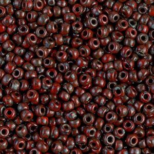 Detailed view of matte glass seed beads in Picasso Opaque Red Garnet shade.