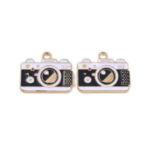 White and black enamel camera charms with gold trim, lens detail and hanging loops.