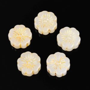 White: White embossed glass flower beads with elegant gold detailing on a contrasting black background.